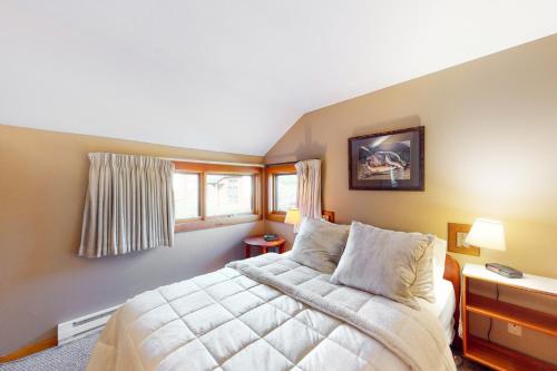 a bedroom with a large bed and two windows at Cozy Modern Comfort in Killington