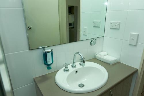 a bathroom with a sink and a mirror at Ashwood Motel in Gosford