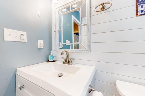 a white bathroom with a sink and a mirror at The Sand Dune in Ocean City