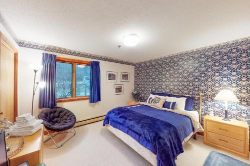 een slaapkamer met een bed, een stoel en een raam bij Ober Tal Getaway in Stratton