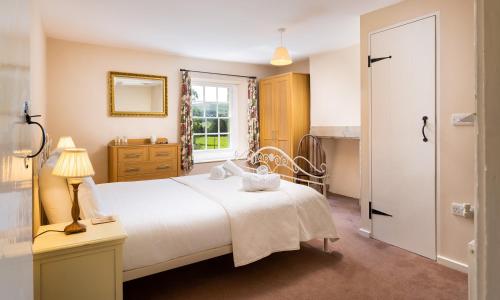 a bedroom with a white bed and a window at Kent Cottage in Cockermouth