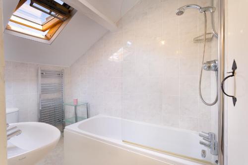 y baño con bañera, lavamanos y ducha. en Kent Cottage, en Cockermouth