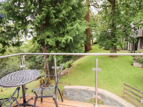 a balcony with a table and chair on a porch at Fir Howe in Ambleside