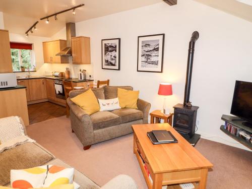 a living room with a couch and a stove at Fir Howe in Ambleside