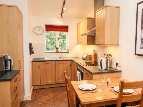 a kitchen with wooden cabinets and a wooden table at Fir Howe in Ambleside