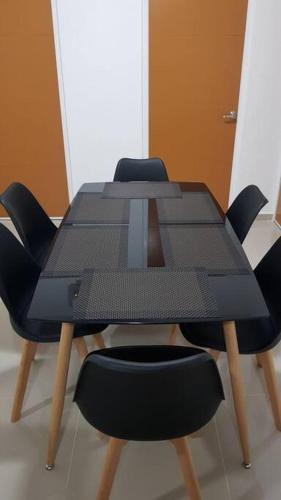 a black table with four chairs around it at Hermoso y cómodo departamento en Manzanillo in Manzanillo