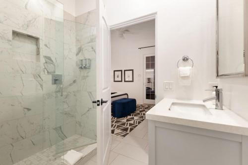 a white bathroom with a shower and a sink at Santal Estate - Play, Relax, Walk to the Festivals in Indio