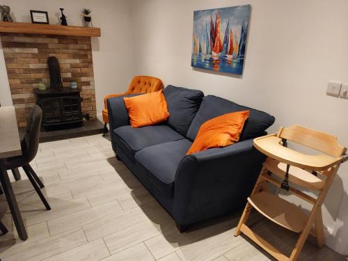 a living room with a blue couch with orange pillows at Amy's Place Charming 3 Bed House Donegal Sleeps 5 in Donegal