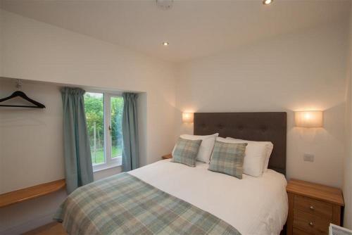 a bedroom with a bed with pillows and a window at Mylnbeck in Windermere