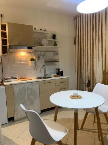 a kitchen with a white table and chairs in a kitchen at Macadà in Bari