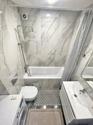 a bathroom with a tub and a toilet and a sink at Beautiful Apartment in Chisinau in Chişinău