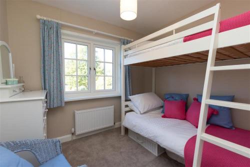a bedroom with two bunk beds and a ladder at Crozier Cottage in Ambleside