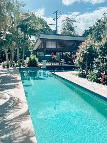 a swimming pool in front of a house at Seadrift Byron in Byron Bay