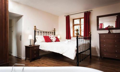 1 dormitorio con cama, tocador y espejo en The Old Chapel, en Windermere
