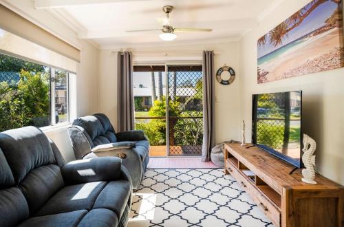 a living room with a couch and a table at Fins Hideaway in Iluka