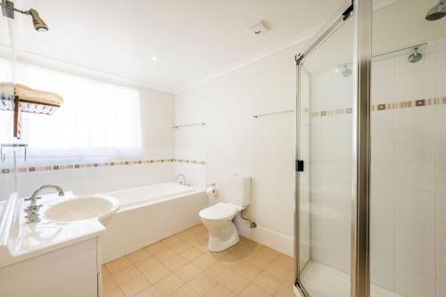 een badkamer met een toilet, een wastafel en een douche bij Fins Hideaway in Iluka
