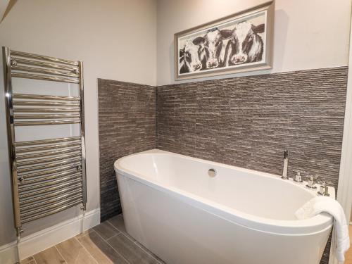uma banheira branca na casa de banho com uma parede de azulejos em Hazeldene em Ambleside