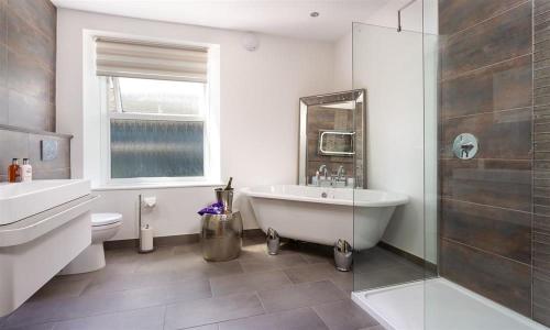 ein Badezimmer mit einer Badewanne, einem WC und einem Waschbecken in der Unterkunft Fell Cottage in Ambleside