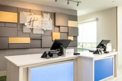 a reception desk with two computers on top of it at Holiday Inn Express & Suites - San Jose Silicon Valley by IHG in San Jose