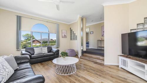 a living room with a couch and a tv at Emerald Escape Lighthouse Beach in Port Macquarie