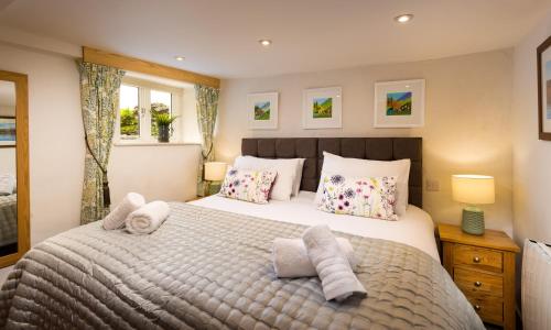 a bedroom with a large bed with towels on it at Pennys Cottage in Troutbeck