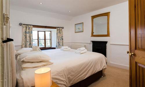 a bedroom with a large bed with towels on it at Curdle Dub in Coniston