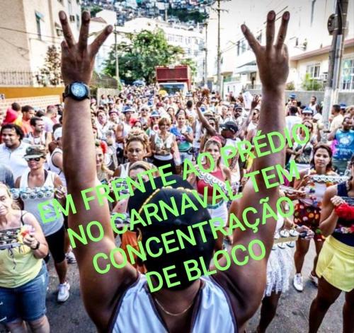 a crowd of people holding up their hands in the street at Quitinete ACONCHEGANTE in Rio de Janeiro