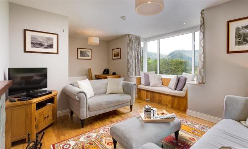 a living room with a couch and a tv at Cherry Garth in Patterdale