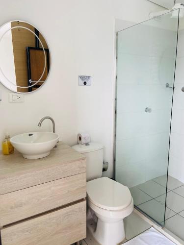 a bathroom with a toilet and a sink and a mirror at La Madriguera in Guatapé