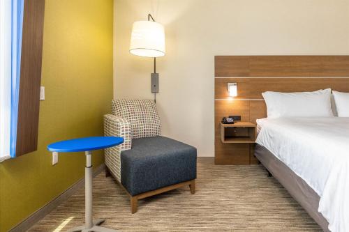 a hotel room with a bed and a chair and a desk at Holiday Inn Express & Suites - San Jose Silicon Valley by IHG in San Jose