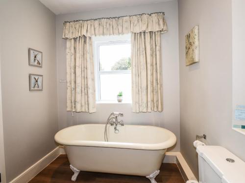 a white bath tub in a bathroom with a window at The Mews in Ambleside