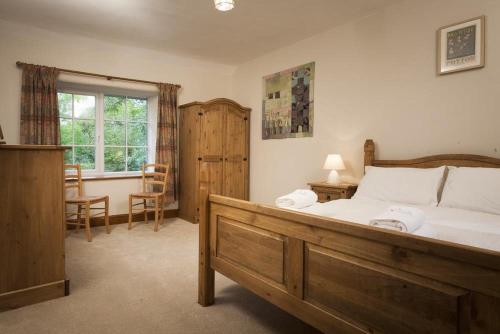 a bedroom with a bed and a table and a window at Wythebank in Ambleside