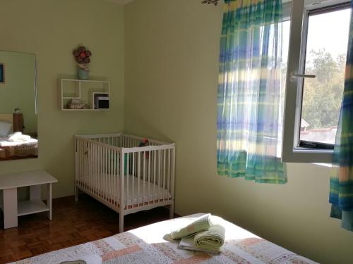 Una cuna en un dormitorio con ventana y cuna en Apartment Njivice 5320b en Njivice