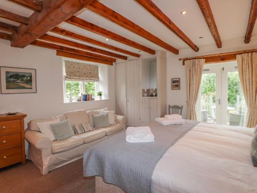 Glen View Cottage في آمبيلسايد: غرفة نوم بسرير كبير وأريكة