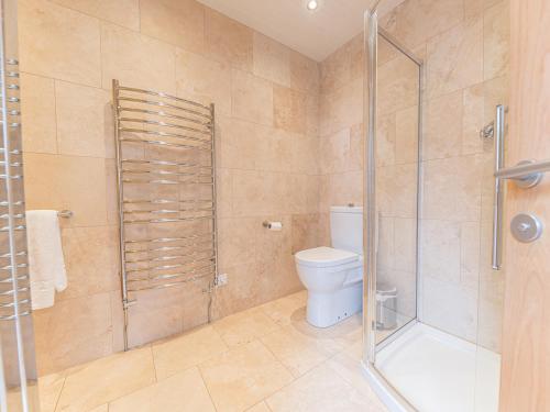 a bathroom with a toilet and a glass shower at Cedar Wood Coniston in Coniston
