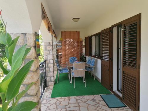 a patio with a table and chairs on a balcony at Apartments with a parking space Njivice, Krk - 5320 in Njivice