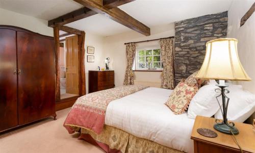 ウルバーストンにあるBank Barn at Ruslandのベッドとテーブルの上にランプが置かれた寝室