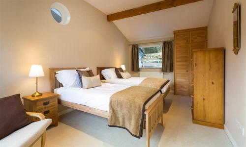 a bedroom with two beds and a couch in it at Felldale in Glenridding