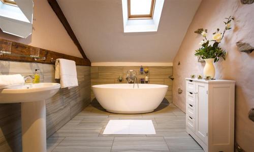 baño con bañera grande y lavamanos en Scalegill House, en Cockermouth