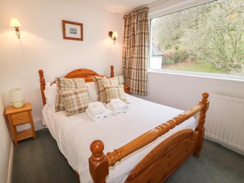 a bedroom with a bed and a large window at Weir Cottage in Ambleside