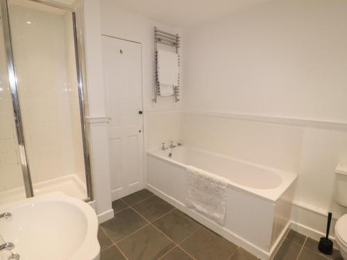 a bathroom with a tub and a toilet and a sink at Weir Cottage in Ambleside