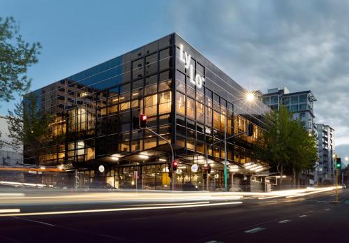 un grand bâtiment en verre avec une rue en face dans l'établissement LyLo Auckland, à Auckland