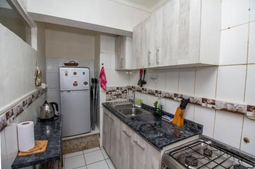 una cucina con armadietti bianchi e frigorifero bianco di Departamento Freire a Valparaíso
