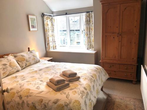 1 dormitorio con 1 cama con 2 toallas en White Lion Cottage en Chapel Stile