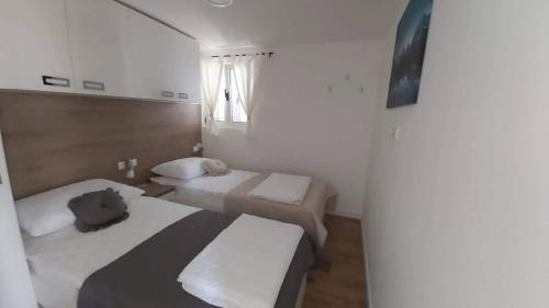 een kleine kamer met 2 bedden en een raam bij Holiday house with a parking space Kastel Stari, Kastela - 20226 in Kaštel Štafilić