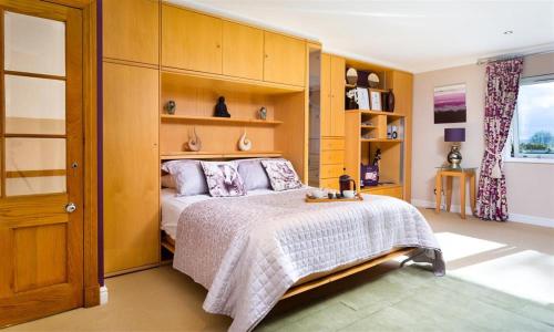 una camera con un grande letto e scaffali in legno di The Gallery ad Ambleside