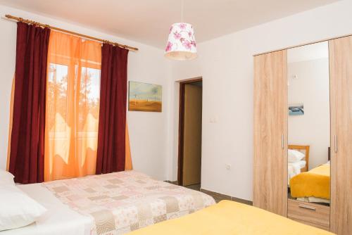 een slaapkamer met 2 bedden en een spiegel bij Family friendly house with a swimming pool Cista Velika, Vodice - 20234 in Velika Čista