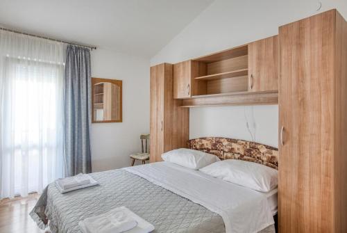 - une chambre avec un grand lit et une tête de lit en bois dans l'établissement Apartments by the sea Rogoznica - 2895, à Rogoznica