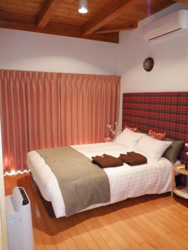 a bedroom with a large bed with a red headboard at Enako Villas in Takayama