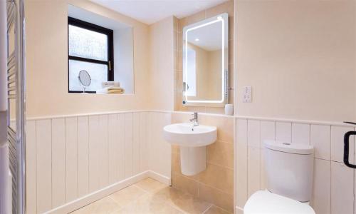 a white bathroom with a sink and a toilet at Thirlmere Cottage in Keswick